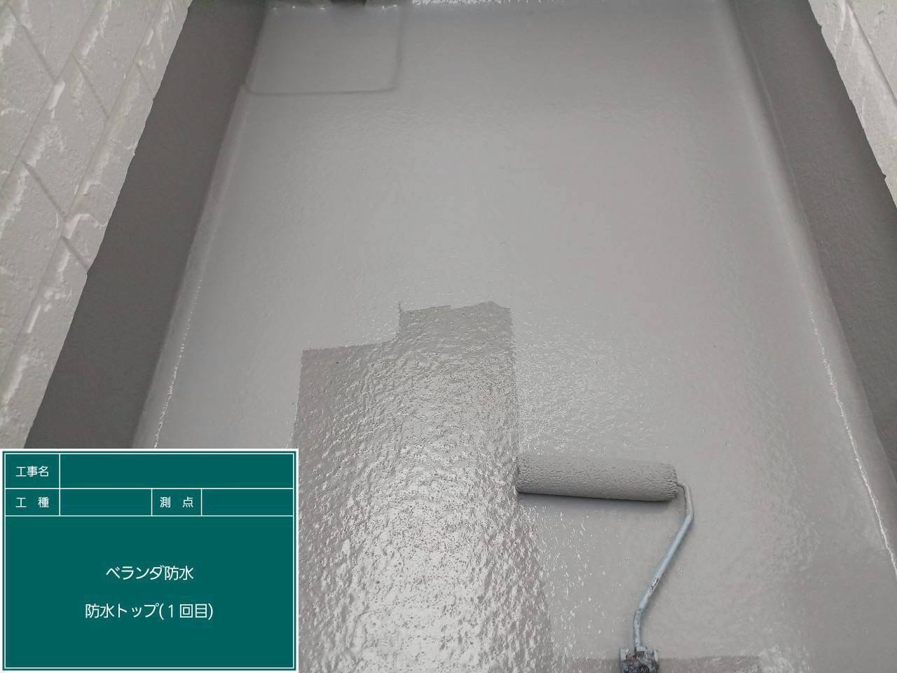 バルコニー床にトップコート1回目を施工中